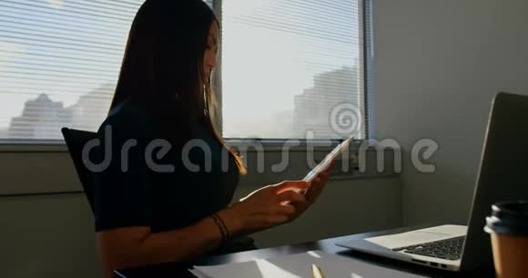 年轻的高加索女商人在一个现代化的办公室里做数码平板电脑的侧视视频的预览图