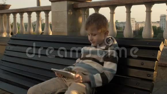 快乐的小男孩使用平板电脑视频的预览图