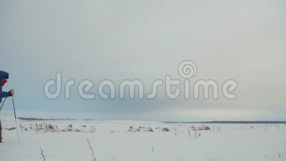 三个徒步旅行者带着徒步旅行杆一个背包和雪鞋徒步旅行者小组冬季旅行愉快视频的预览图