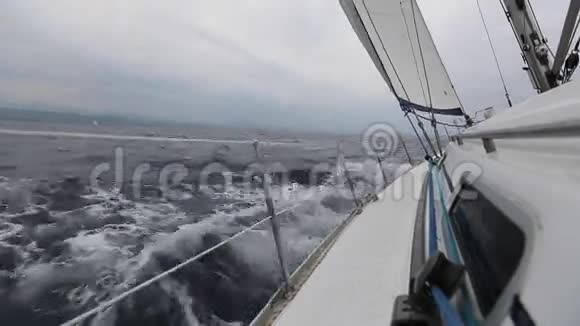 在暴风雨的天气里带着白帆的帆船在海上航行体育运动视频的预览图