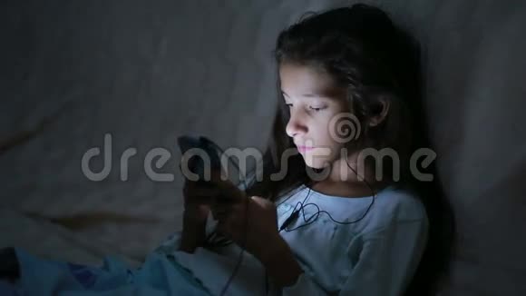 小女孩晚上用手机视频的预览图