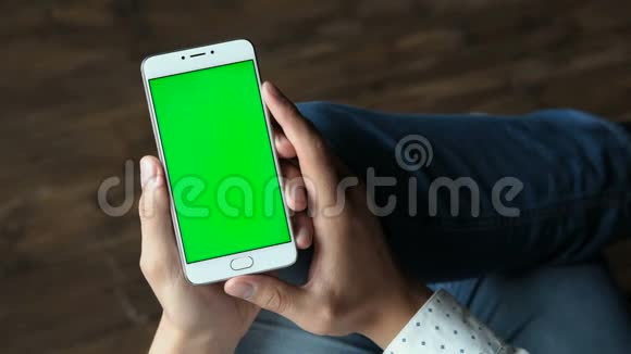 手拿着绿色屏幕的手机视频的预览图