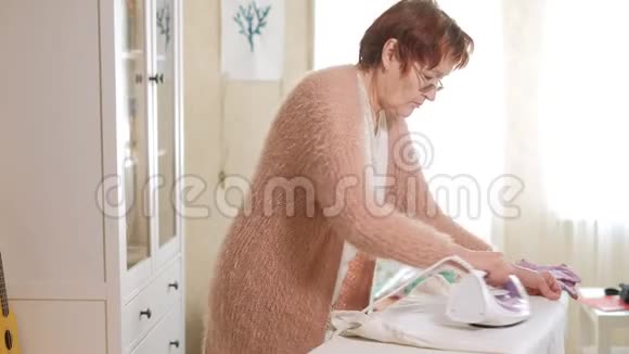 老妇人在家熨衣服视频的预览图