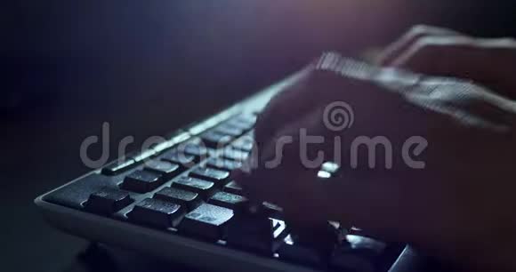晚上在键盘上打字暗色背景照明特写视频的预览图