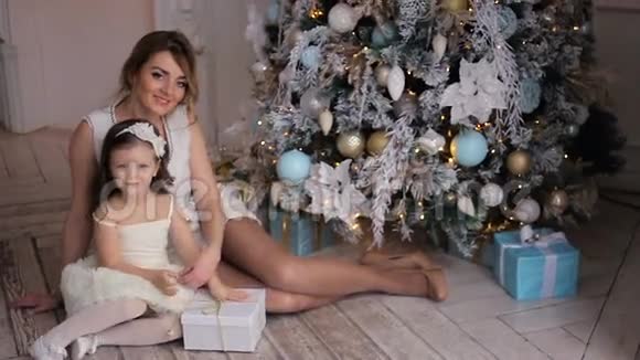 母亲和女儿坐在圣诞树前三年视频的预览图