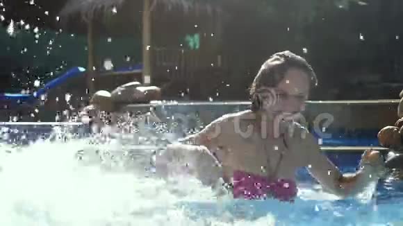 快乐的年轻女子慢吞吞地在游泳池里泼水1920x1080视频的预览图