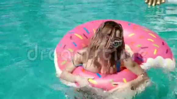 低角度拍摄蓝色游泳池的水和女孩飞溅同时抓住20岁1080p慢速运动视频的预览图