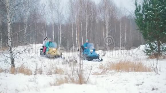在冬季森林里骑雪地车的年轻人视频的预览图