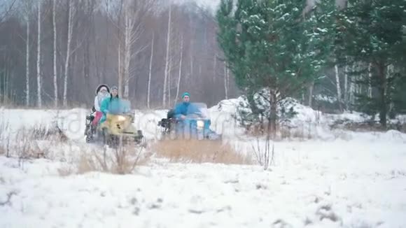 冬季森林骑雪地车的年轻人视频的预览图