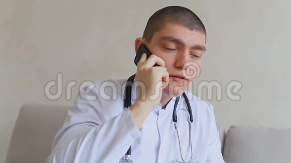 手机上的好医生给坐在医院办公室沙发上的病人提供建议视频的预览图