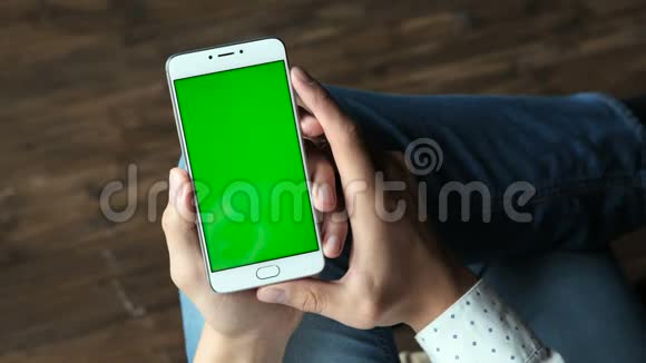 手拿着绿色屏幕的手机视频的预览图