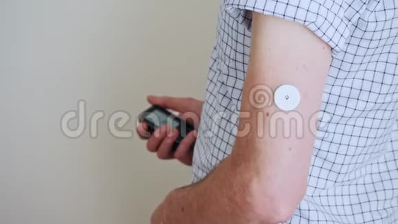 一个人把读数装置带到传感器来测量葡萄糖视频的预览图