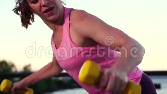 年轻女运动员在海滩上练习健身视频的预览图