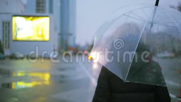 雨中带伞的女孩走在街上的秋女人视频的预览图