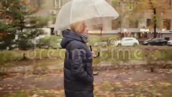 雨中带伞的女孩走在街上的秋女人视频的预览图