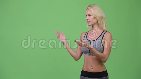 年轻快乐的漂亮女人展示准备去健身房的东西视频的预览图