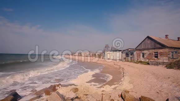海岸上的建筑被毁海边的秋意沙滩上的波浪翻滚视频的预览图