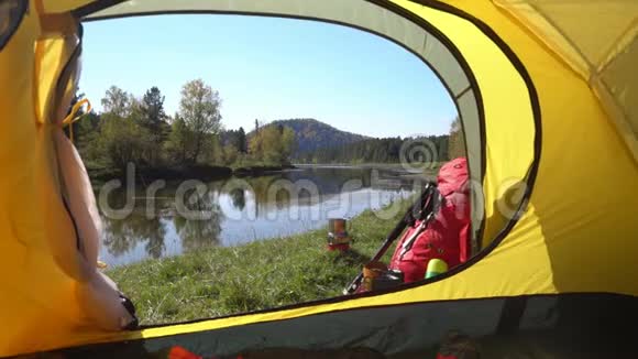 这顶黄色的帐篷在山湖畔卖红色背包和旅游靴视频的预览图