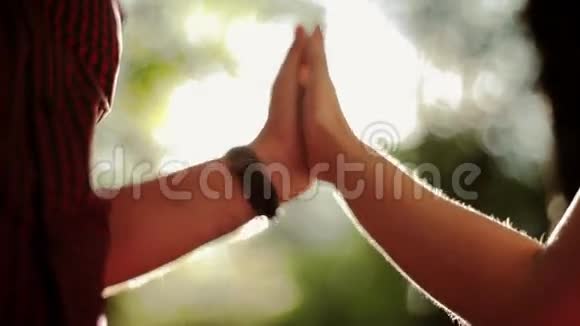 在绿色的夏日森林里牵着相爱的情侣的手太阳光束视频的预览图