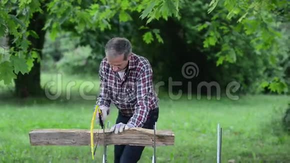 木匠在室外用木锯锯木广场视频的预览图