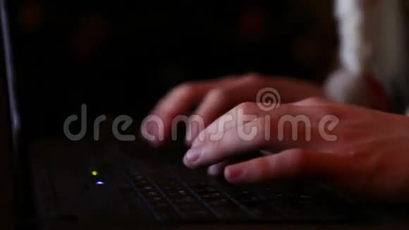男子手提电脑打字特写镜头与圣诞树加兰背景视频的预览图