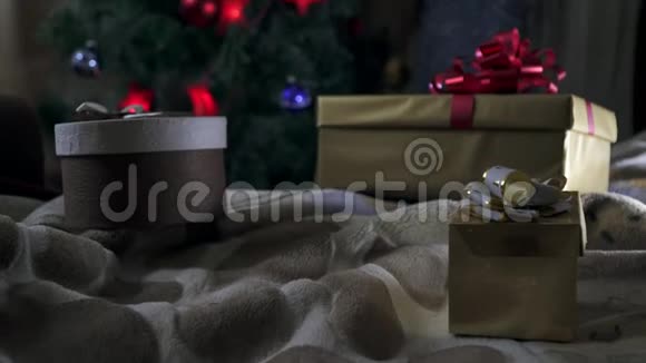 一个女孩拿着礼物坐在圣诞树下视频的预览图
