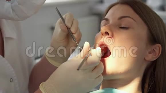 牙科医生在临床上为女性患者治疗牙齿工作中的女专业医生牙科检查视频的预览图