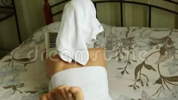 穿着毛巾身体整洁的女孩躺在床上看书视频的预览图