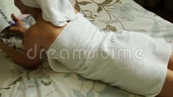 穿着毛巾身体整洁的女孩躺在床上看书视频的预览图