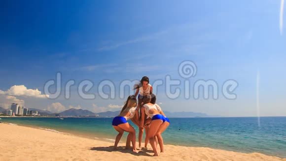 穿白色蓝色衣服的啦啦队员在沙滩上表演篮筐视频的预览图