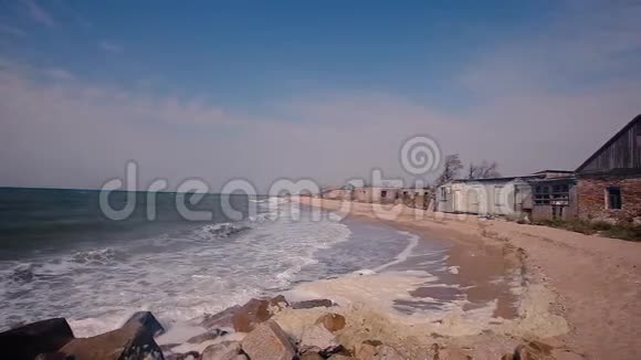 海岸上的建筑被毁海边的秋意沙滩上的波浪翻滚视频的预览图