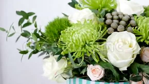 特写花花束白色背景上的旋转花的组成由布鲁尼亚绿色雪崩玫瑰组成视频的预览图