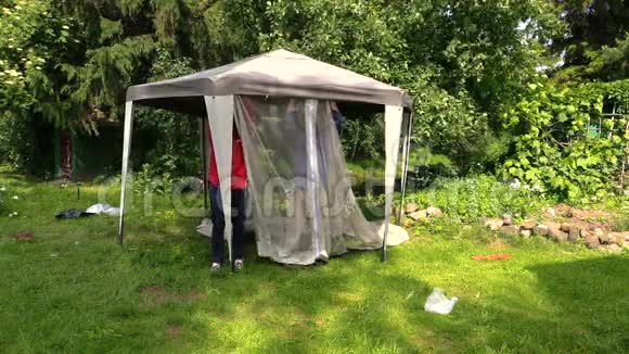 父子俩在花园里搭起了保护帐篷的淋浴网视频的预览图