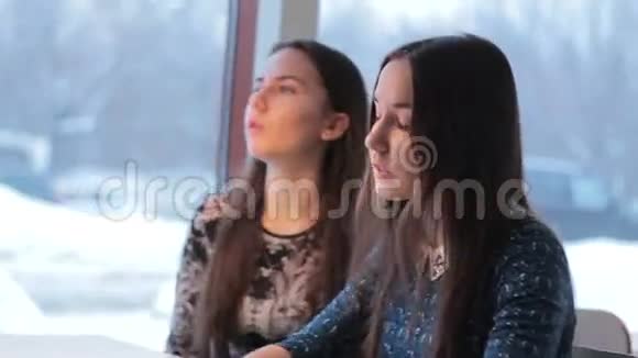 冬天双胞胎女孩在咖啡馆里聊天视频的预览图