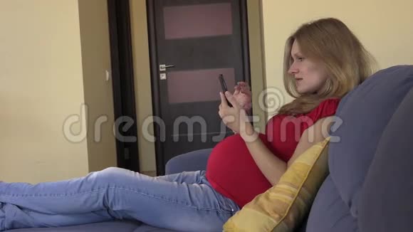 孕妇用智能手机浏览照片和上网视频的预览图