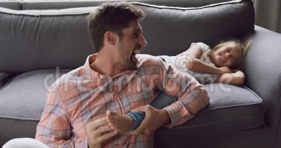 爸爸和女儿一起在家里的沙发上玩耍视频的预览图