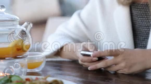 咖啡馆里有智能手机的快乐年轻女子视频的预览图