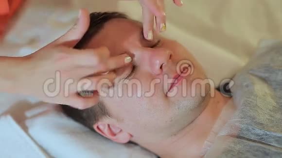 在水疗中心按摩的人按摩脸部和颈部视频的预览图