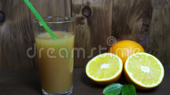 玻璃杯中的橙汁和木制背景的新鲜水果视频的预览图