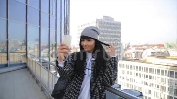 时尚美丽的西班牙拉丁女人在城里的智能手机上发短信喝着拿铁咖啡视频的预览图
