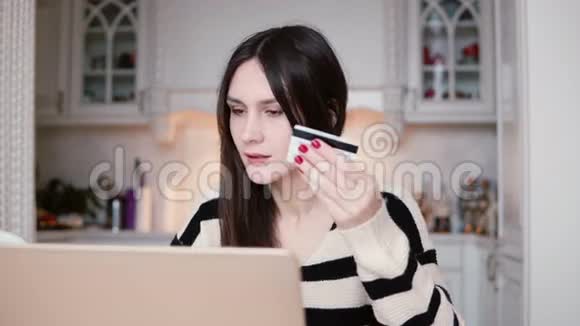 迷人的年轻微笑的女人使用塑料信用卡购物在线笔记本电脑视频的预览图