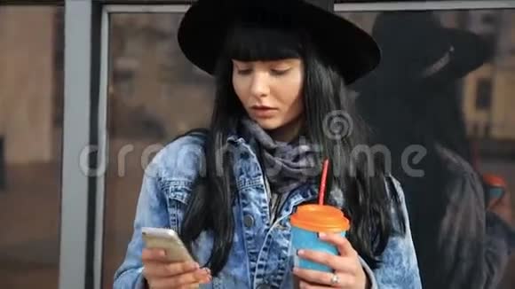 时尚美丽的西班牙拉丁女人在城里的智能手机上发短信喝着拿铁咖啡视频的预览图