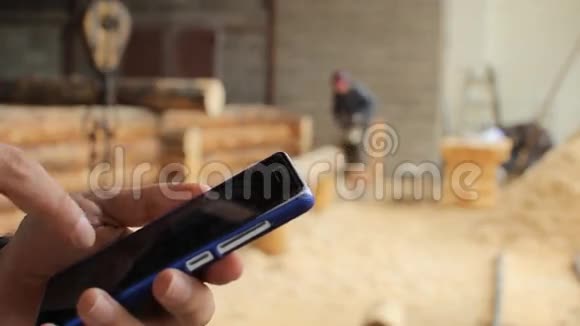 年轻人林业工程师在木头前触摸电话视频的预览图