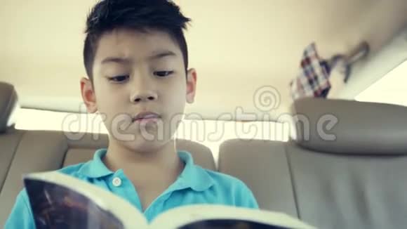 小亚洲男孩在车上看书视频的预览图