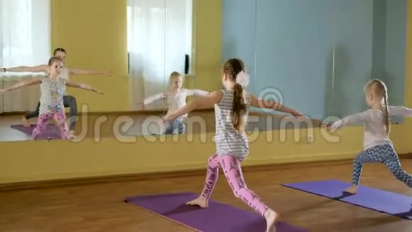妈妈和女儿们一起在健身室做瑜伽视频的预览图