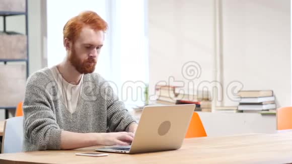 男子接听电话在笔记本电脑上工作视频的预览图