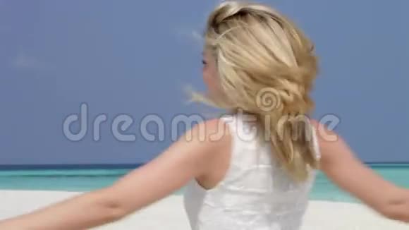 在美丽的海滩上伸展手臂的女人视频的预览图
