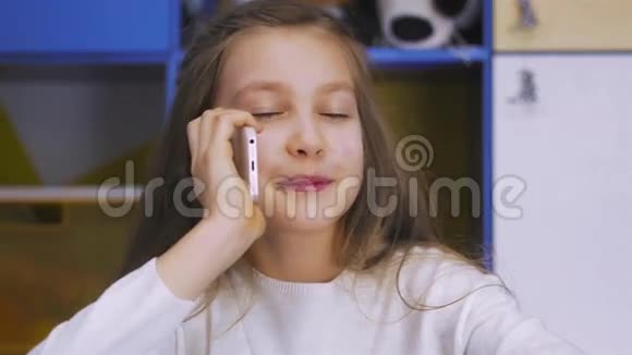 可爱的小女孩使用现代智能手机视频的预览图