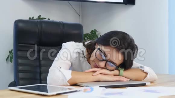疲惫的女商人睡在桌子上视频的预览图