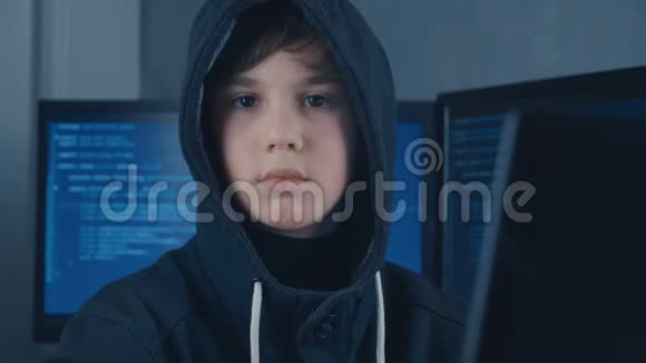 一个年轻的巨人男孩黑客程序员的肖像在数据中心充满显示屏幕儿童肖像视频的预览图